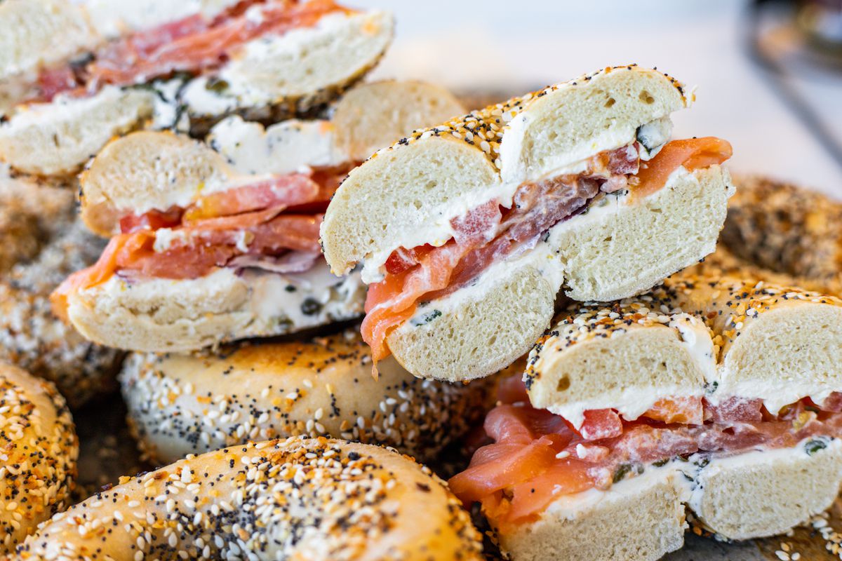 Many stacked everything bagels with cream cheese and lox