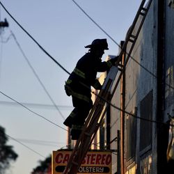 A firefighter climbs a ladder after a deadly fire at a warehouse rave party in Oakland, Calif., earlier in the morning on Dec. 3, 2016. 