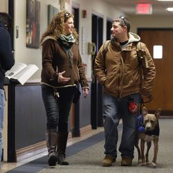 Apryl Lea, center, certified trainer of Assistance Dog Training Program at the Animal Farm Foundation, walks with former U.S. Marine Joe Bonfiglio, 24, and his pit bull assistance dog Zen, on the campus of Mercy College, in Dobbs Ferry, N.Y., Wednesday, Feb. 4, 2015.  Zen has allowed Bonfiglio, 24, who was diagnosed with post-traumatic stress disorder , to get back to everyday activities.  The Animal Farm Foundation in Dutchess County, New York, wants to change the stigma of pit bull dogs by training and donating rescued dogs to guide the blind and push wheelchairs or help people regain their mobility and avoid falls.  