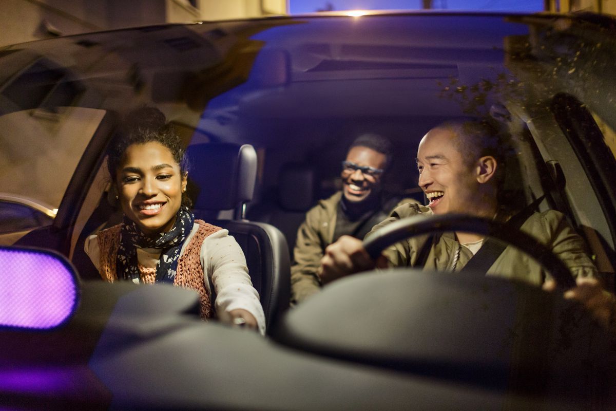 A Lyft driver takes two passengers to their destination.