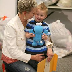 Jan Gray holds her grandson Sawyer Mead as they are surrounded by bags of stuffed animals donated in memory of fatal crash victim Stacie Mae Gray, Jan's daughter, at Utah Highway Patrol Headquarters in Salt Lake City on Thursday, April 4, 2013. The stuffed animals are used to comfort children involved in car crashes and also distributed at car seat checkpoints to reward children for buckling up.