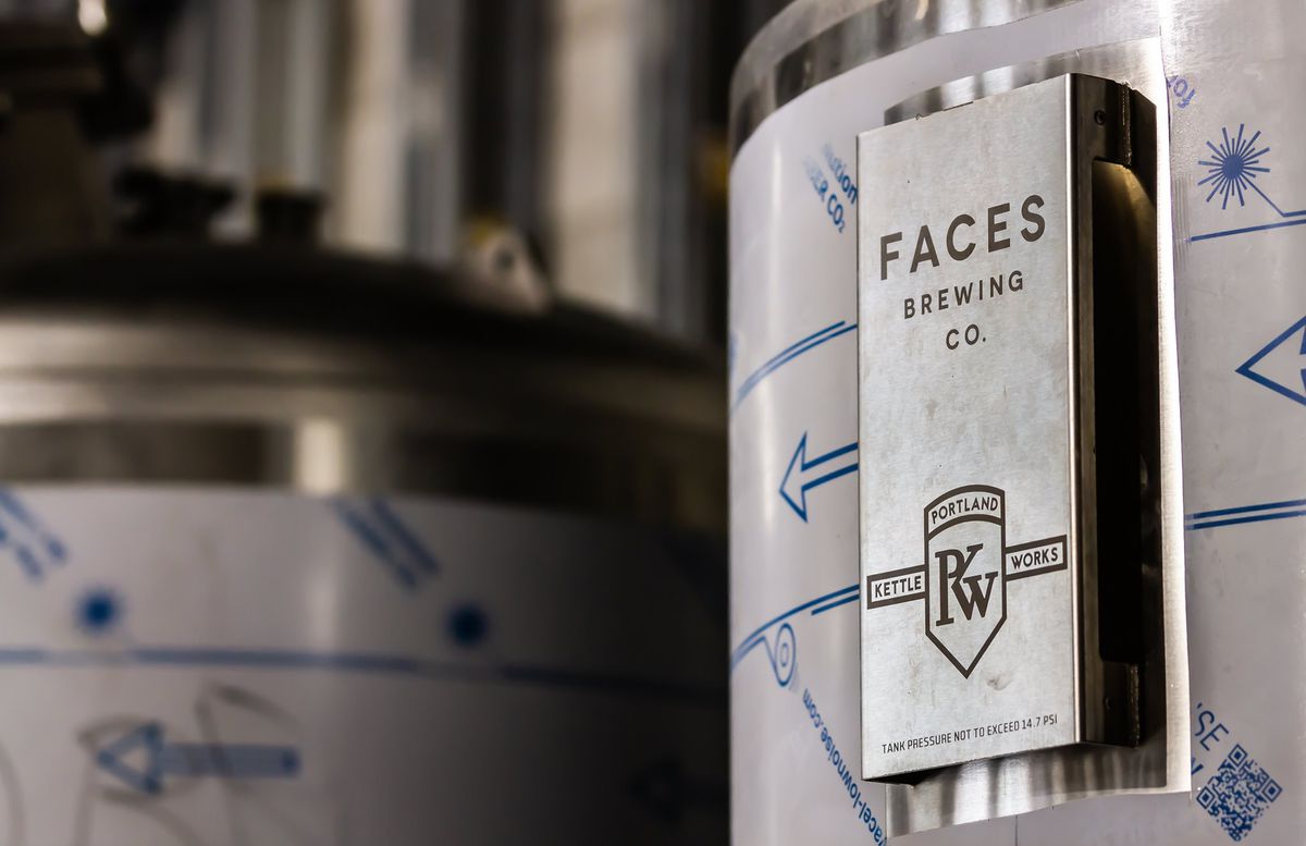 A silver fermentation tank displays the name of Faces Brewing Company, a forthcoming Malden brewery