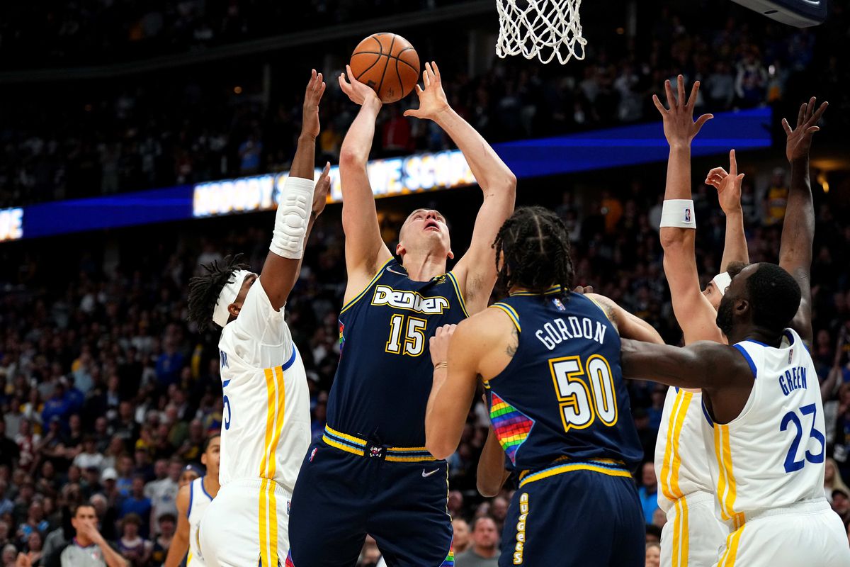 Denver Nuggets center Nikola Jokic (15) shoots past Golden State Warriors center Kevon Looney (5) in the first quarter of the first round for the 2022 NBA playoffs at Ball Arena.&nbsp;