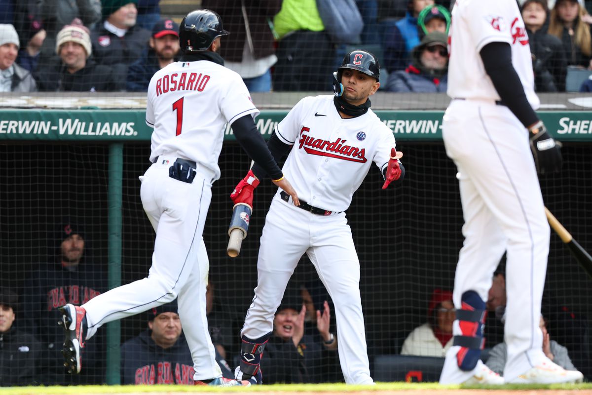 Amed Rosario of the Cleveland Guardians high-fives Andres Gimenez after scoring in the first inning during the game between the Seattle Mariners and the Cleveland Guardians at Progressive Field on Friday, April 7, 2023 in Cleveland, Ohio.