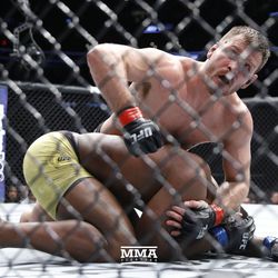 Stipe Miocic leans on Francis Ngannou at UFC 220.