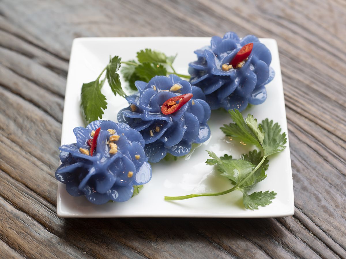 white square plate with three blue dumplings shaped like flowers