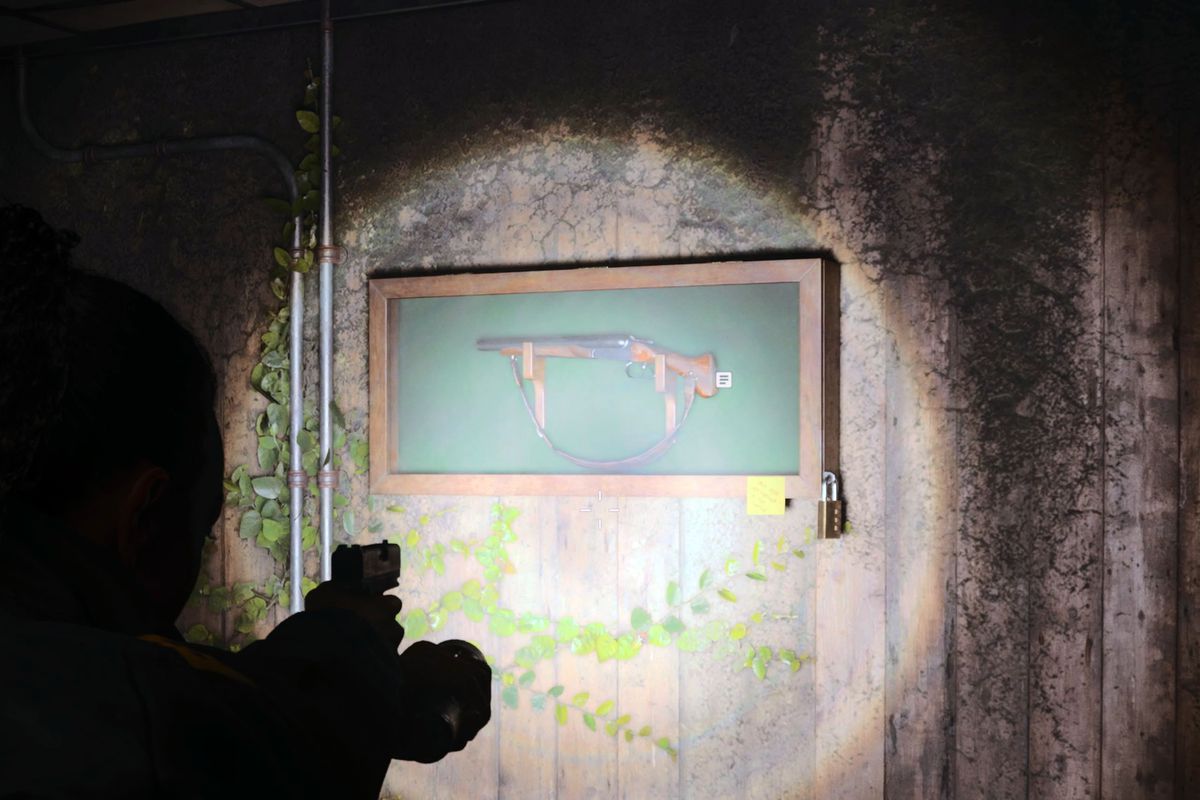 Saga points a gun at a shotgun in a case in the general store in Alan Wake 2