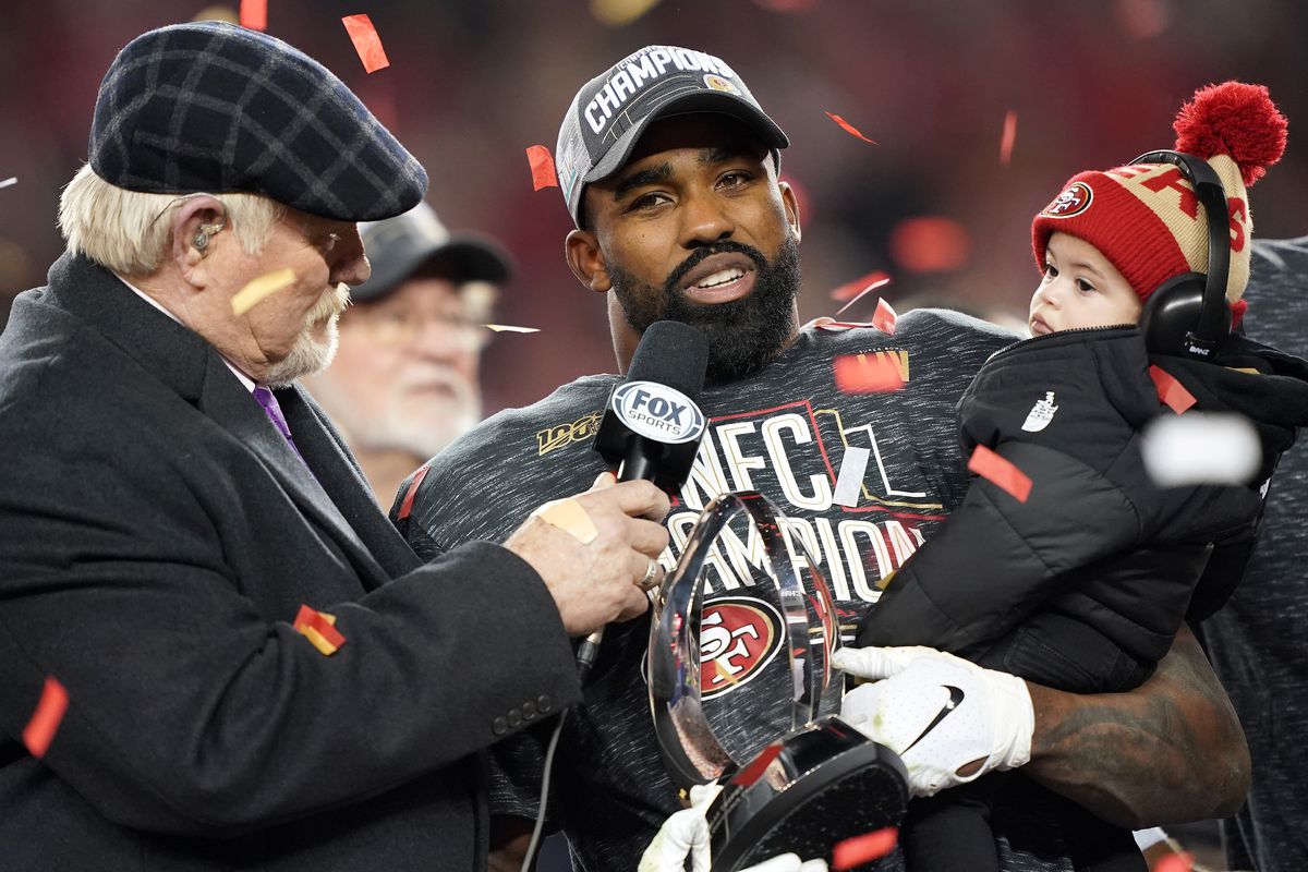 Raheem Mostert #31 of the San Francisco 49ers celebrates with the George Halas Trophy while holding his son, Gunnar, after winning the NFC Championship game against the Green Bay Packers at Levi’s Stadium on January 19, 2020 in Santa Clara, California. The 49ers beat the Packers 37-20.