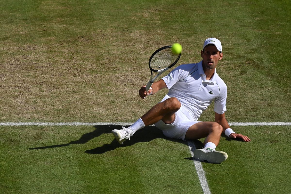 Novak Djokovic of Serbia falls against Cameron Norrie of Great Britain during the Mens’ Singles Semi Final match on day twelve of The Championships Wimbledon 2022 at All England Lawn Tennis and Croquet Club on July 08, 2022 in London, England.