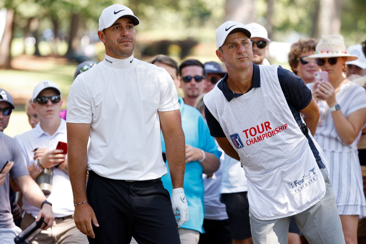 Brooks Koepka and his caddie line up a shot on the seventh hole during the third round of the TOUR Championship at East Lake Golf Club on September 04, 2021 in Atlanta, Georgia.
