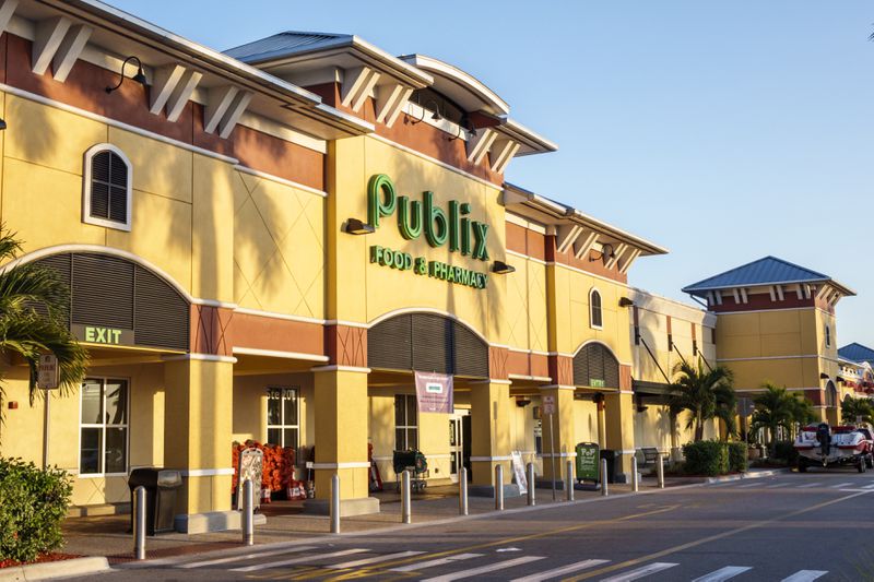 The exterior of a Publix supermarket; a large tan build in a strip mall style.
