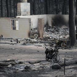 The remains of a motorcycle stands among the ruins of a home along Holmes Road Thursday, June 13, 2013, during the third day of the Black Forest Fire north of Colorado Springs, Colo. 