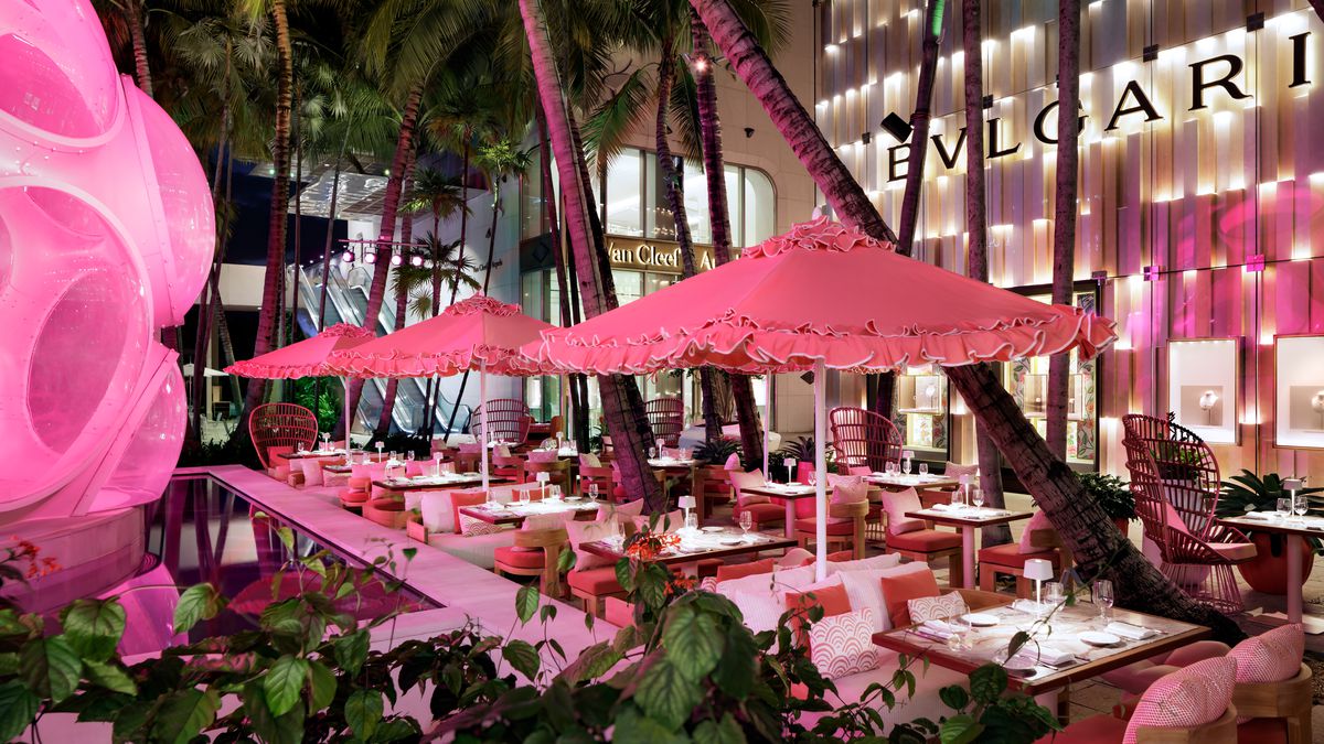 patio area with pink tables and umbrellas.