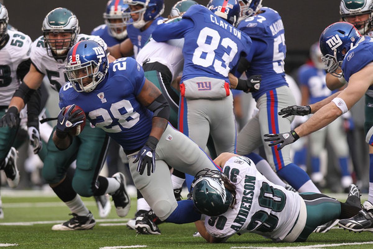 EAST RUTHERFORD NJ - DECEMBER 19: D.J. Ware #28 of the New York Giants is tackled by Colt Anderson #30 of the Philadelphia Eagles at New Meadowlands Stadium on December 19 2010 in East Rutherford New Jersey.  (Photo by Nick Laham/Getty Images)