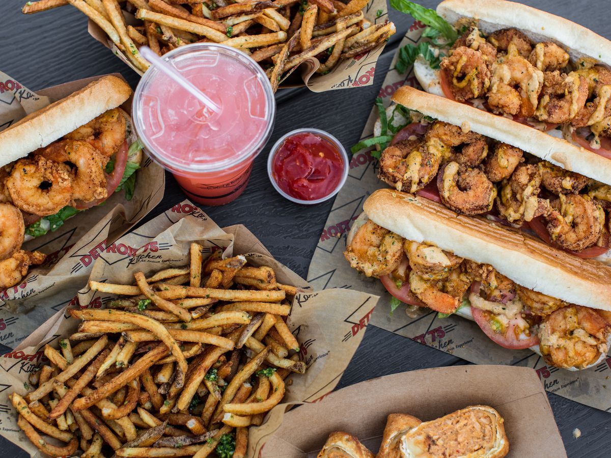 shimp poboy sandwiches and lemonade with baskets of fries shot from overhead
