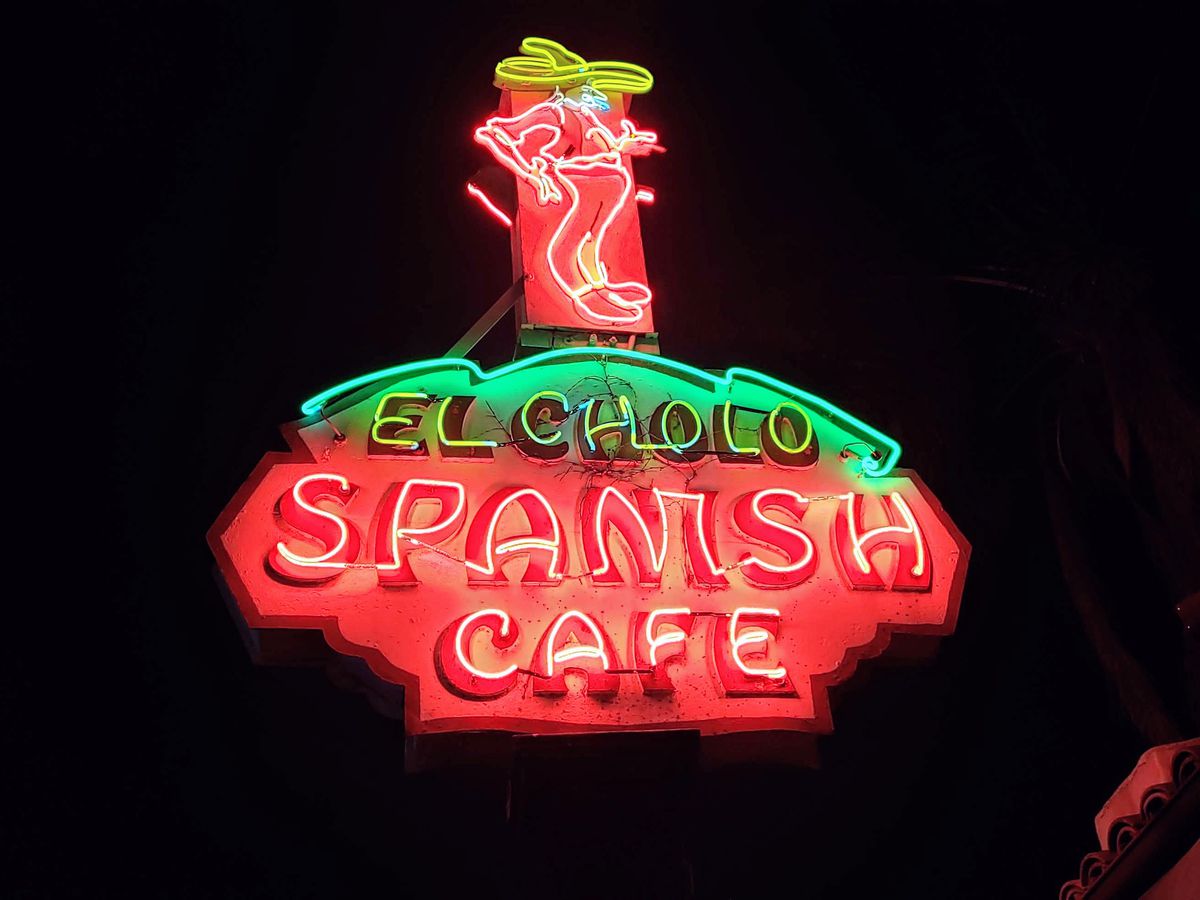 A red and green neon sign for El Cholo restaurant.