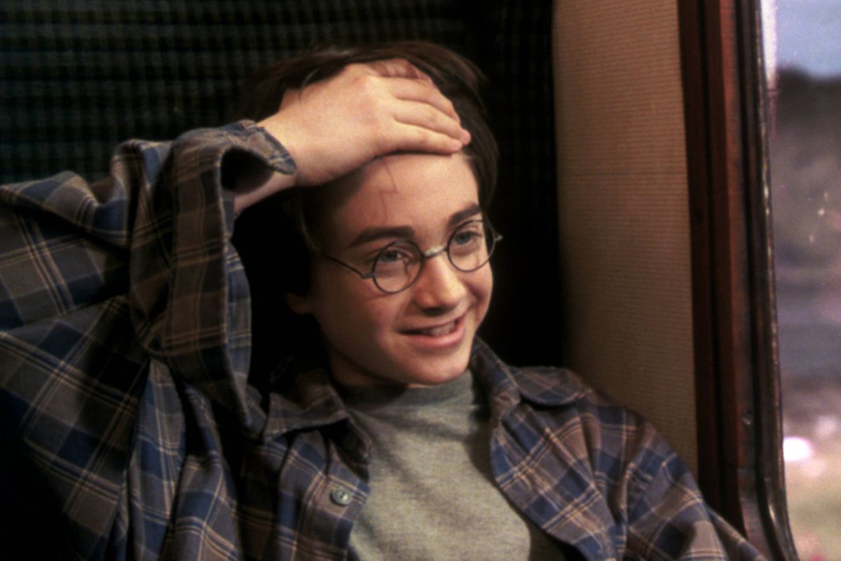 harry potter lifts up his hair to reveal his lightning scar