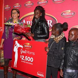 Rebecca Atem, and two of her three children, Ajoh and Nyiel Majok, are presented with a giant gift card by Marsha Gilford, vice president of public affairs at Smith's, for $2,500 as she is honored as part of the Armour “Great Moms” campaign at the YMCA in Taylorsville on Tuesday, Nov. 29, 2016.