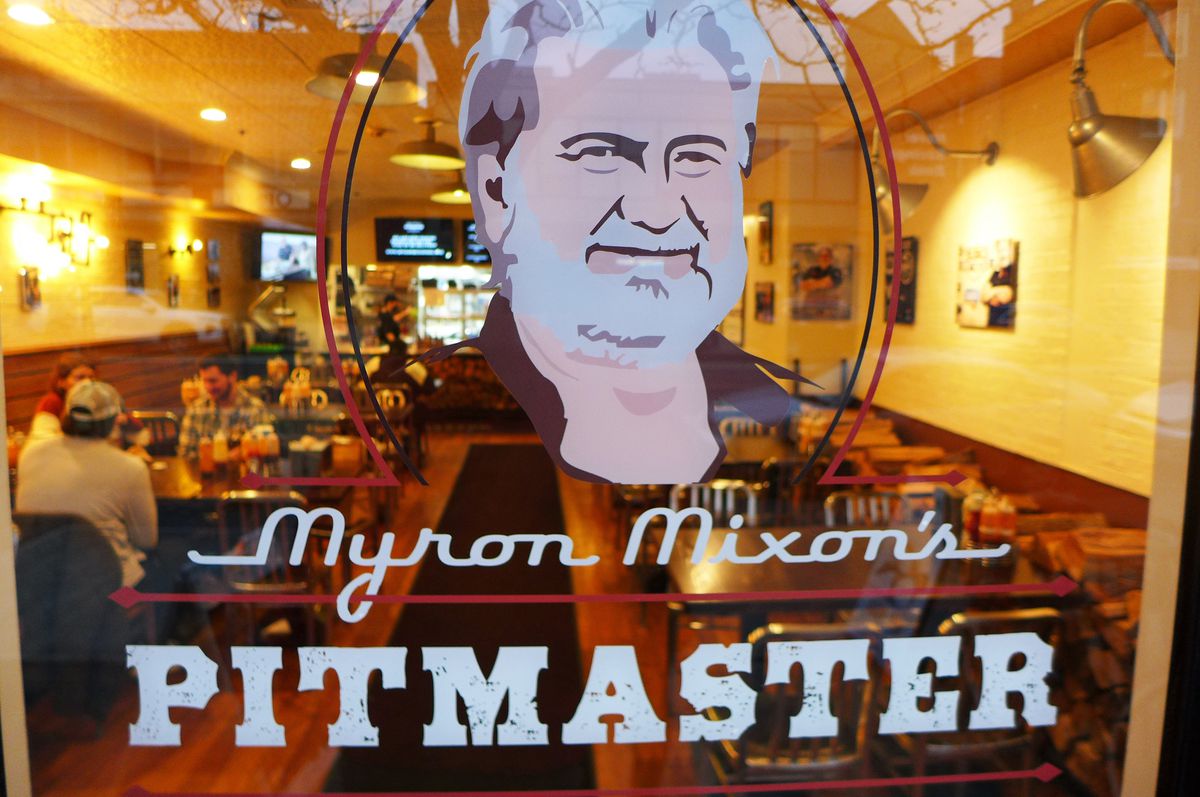 A glass door with a portrait of the pitmaster painted on it.