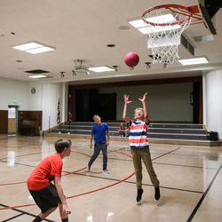 Mason Zabriskie, 12, Colton Galmin, 11, and Jacob Galmin, 9, play basketball at Midvalley Elementary in Midvale on Tuesday, Aug. 22, 2017. The school has a combined gym and auditorium, which is too small to host the entire student population at once, not to mention parents. Low ceilings and no cooling system present problems for the space's use as a gym.