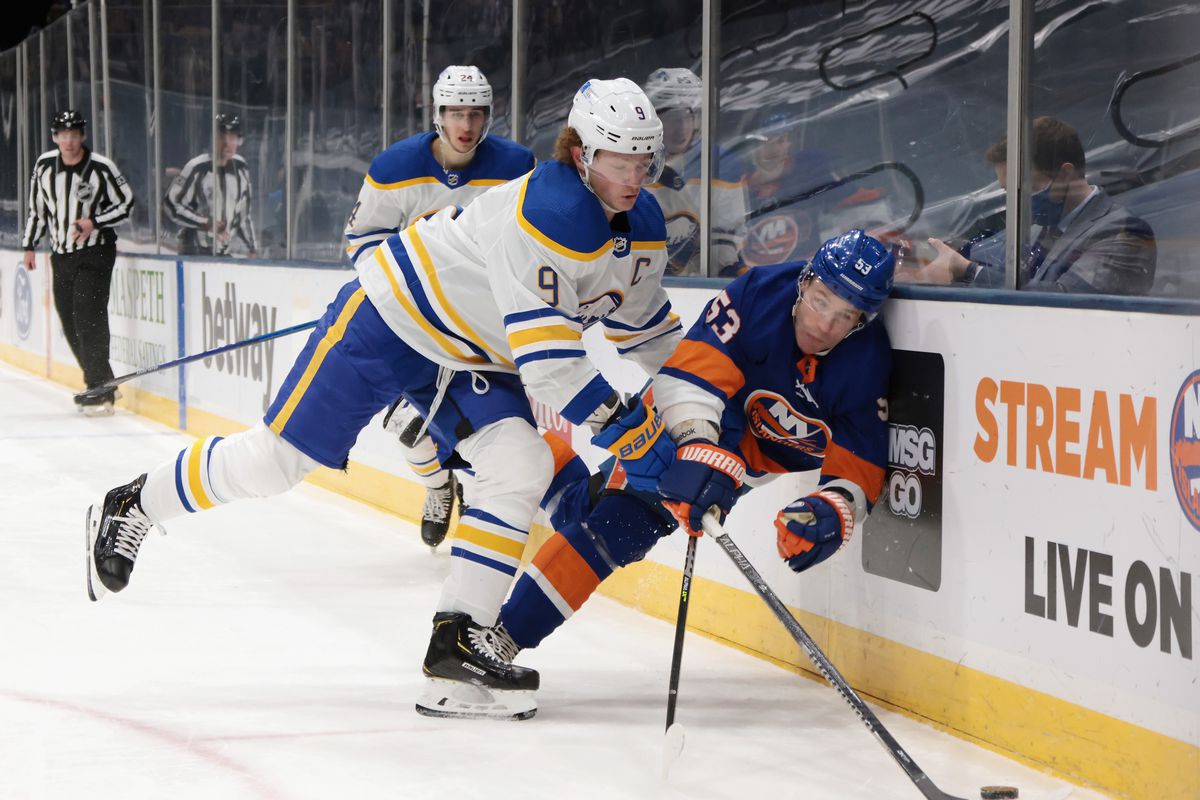 Jack Eichel #9 of the Buffalo Sabres checks Casey Cizikas #53 of the New York Islanders into the boards during the second period at the Nassau Coliseum on March 07, 2021 in Uniondale, New York.
