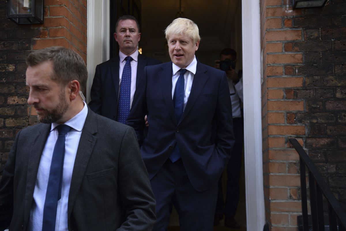 Boris Johnson, right, leaves his office in London on Monday, July 22, 2019.