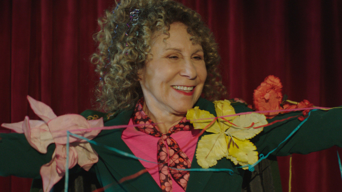 a close up of Rhea Perlman, arms out and awaiting applause