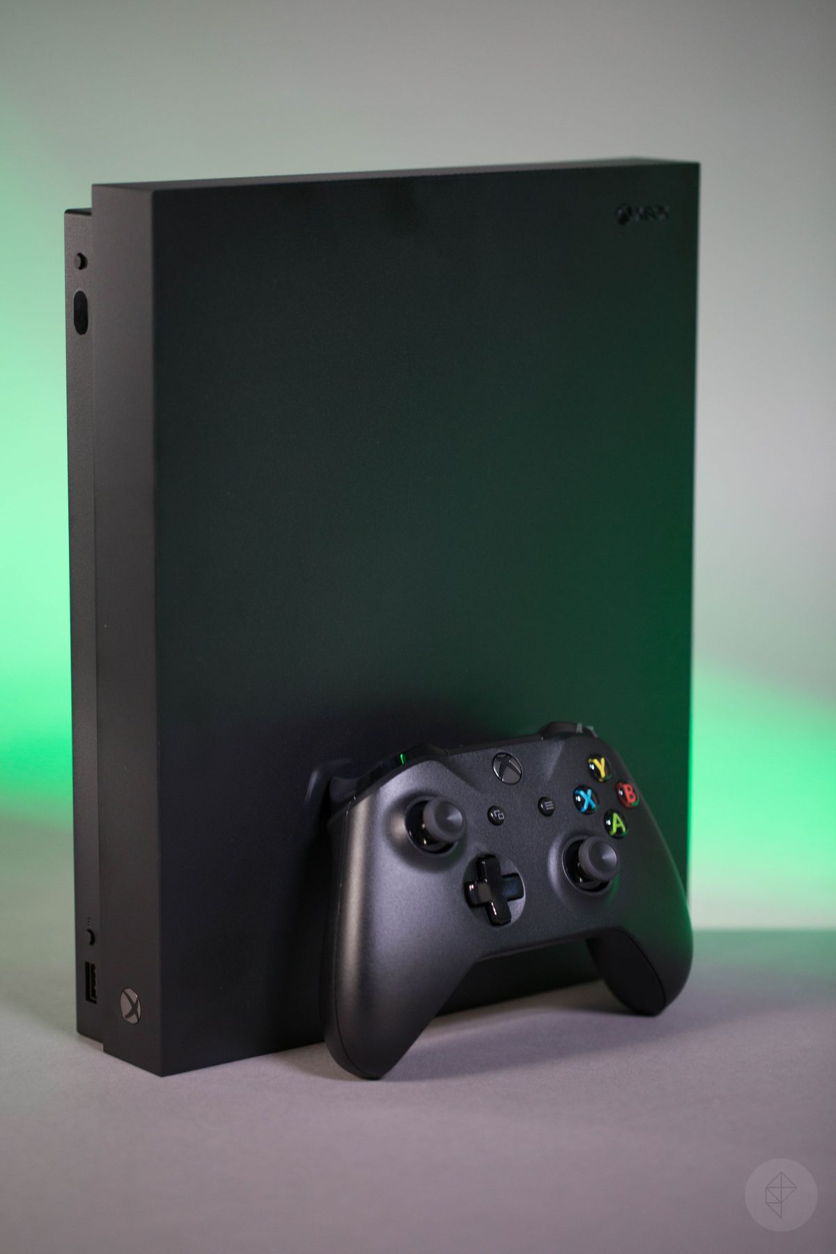 Xbox One X controller standing in front of vertical console