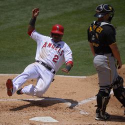 Los Angeles Angels' Erick Aybar, left, scores on a single by J.B. Shuck as Pittsburgh Pirates catcher Michael McKenry looks on during the second inning of their baseball game on Sunday, June 23, 2013, in Anaheim, Calif.  