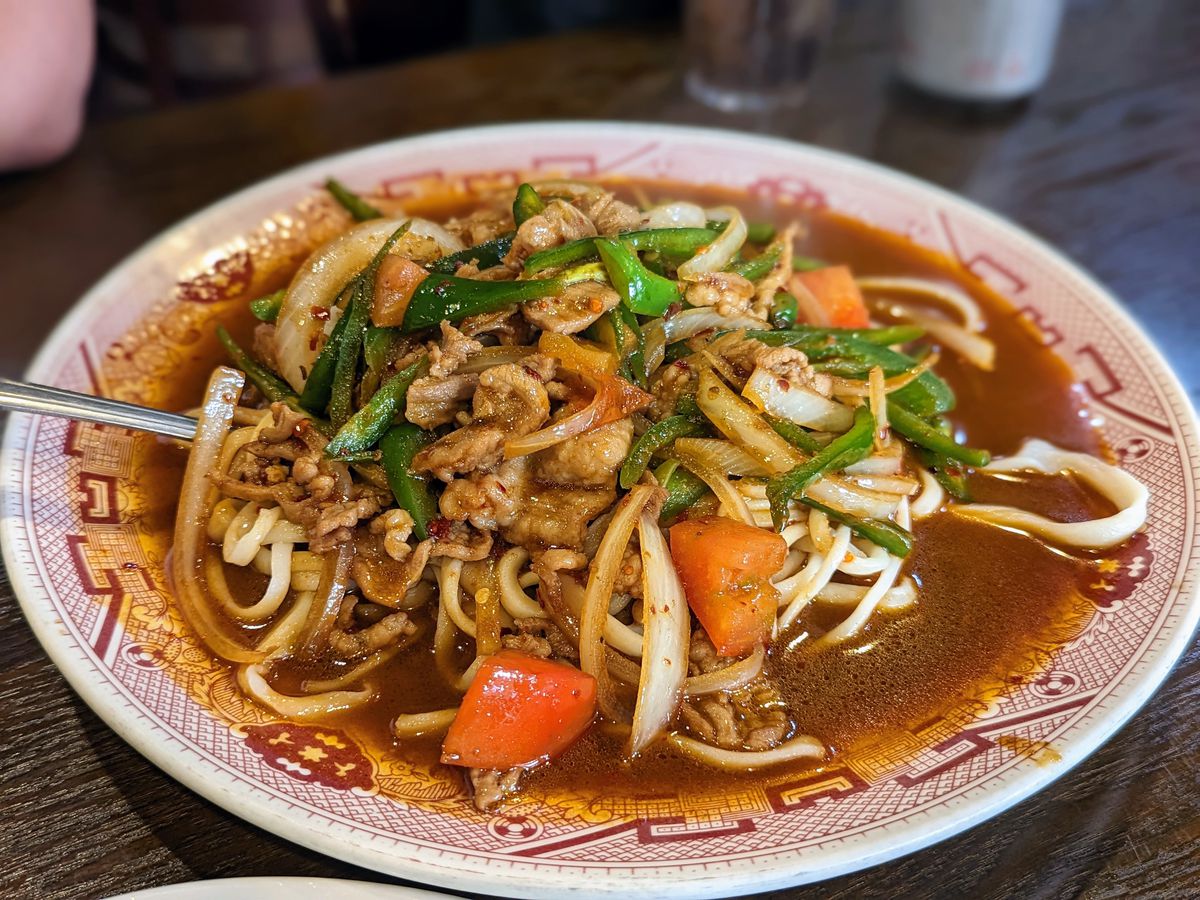 Hand-pulled spicy noodles from Xian Biang Biang in San Gabriel on a decorated plastic plate.