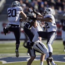 Nevada's Brandon Wimberly (1) tries to catch a pass while being surrounded BYU's Craig Bills (20), Daniel Sorensen, back, and Mike Hague (32) during the first half of an NCAA college football game in Reno, Nev., on Saturday, Nov. 30, 2013.