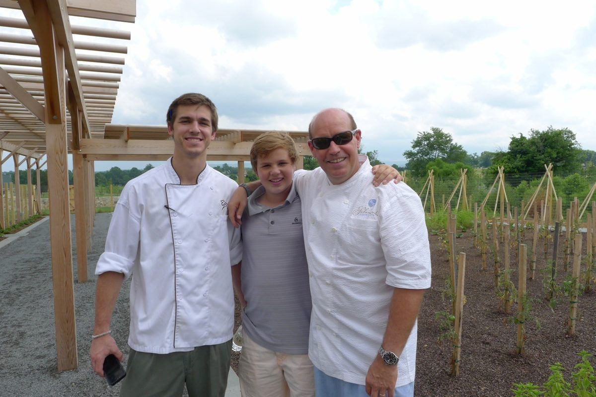 Equinox's chef d’ cuisine Colin McClimans, Todd Gray, and his son Harrison Gray pose in the resort's garden.