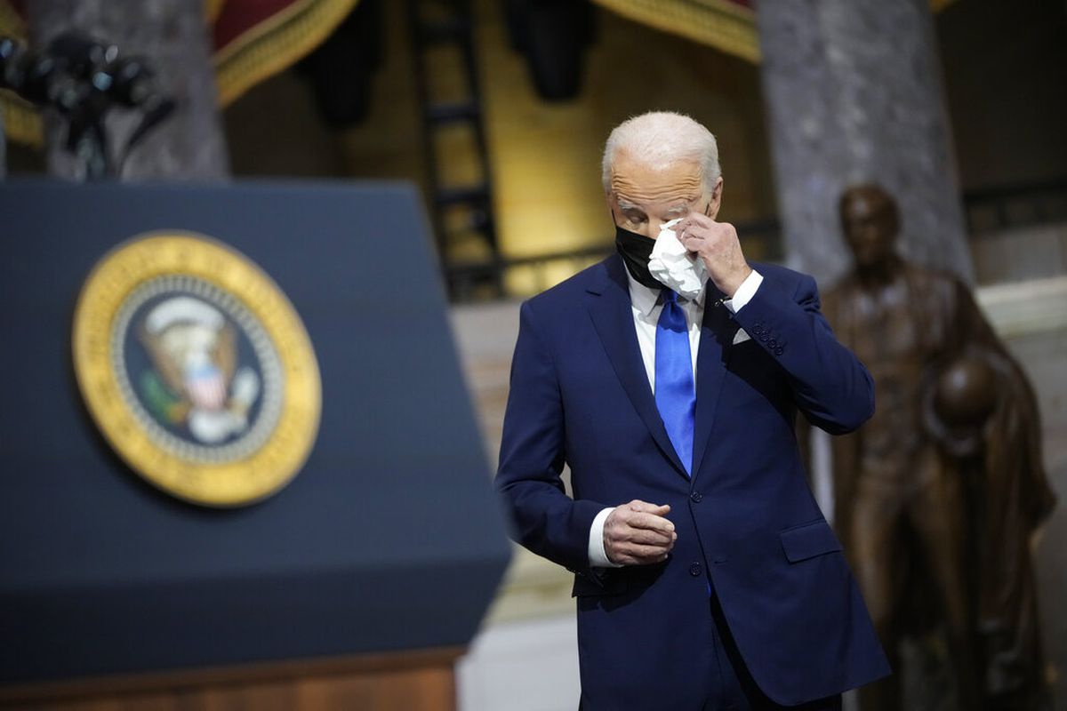 President Joe Biden wipes his eyes as Vice President Kamala Harris speaks.