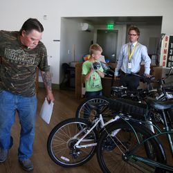 Case manager John Terry, right, helps Duane Feragen, left, and his son, Isaac, 11, pick out a free, donated bicycle at Lantern House in Ogden on Friday, July 22, 2016. The Feragens lost their home in May and lived on the streets for a while before coming to Lantern House, where they've been staying for six weeks.
