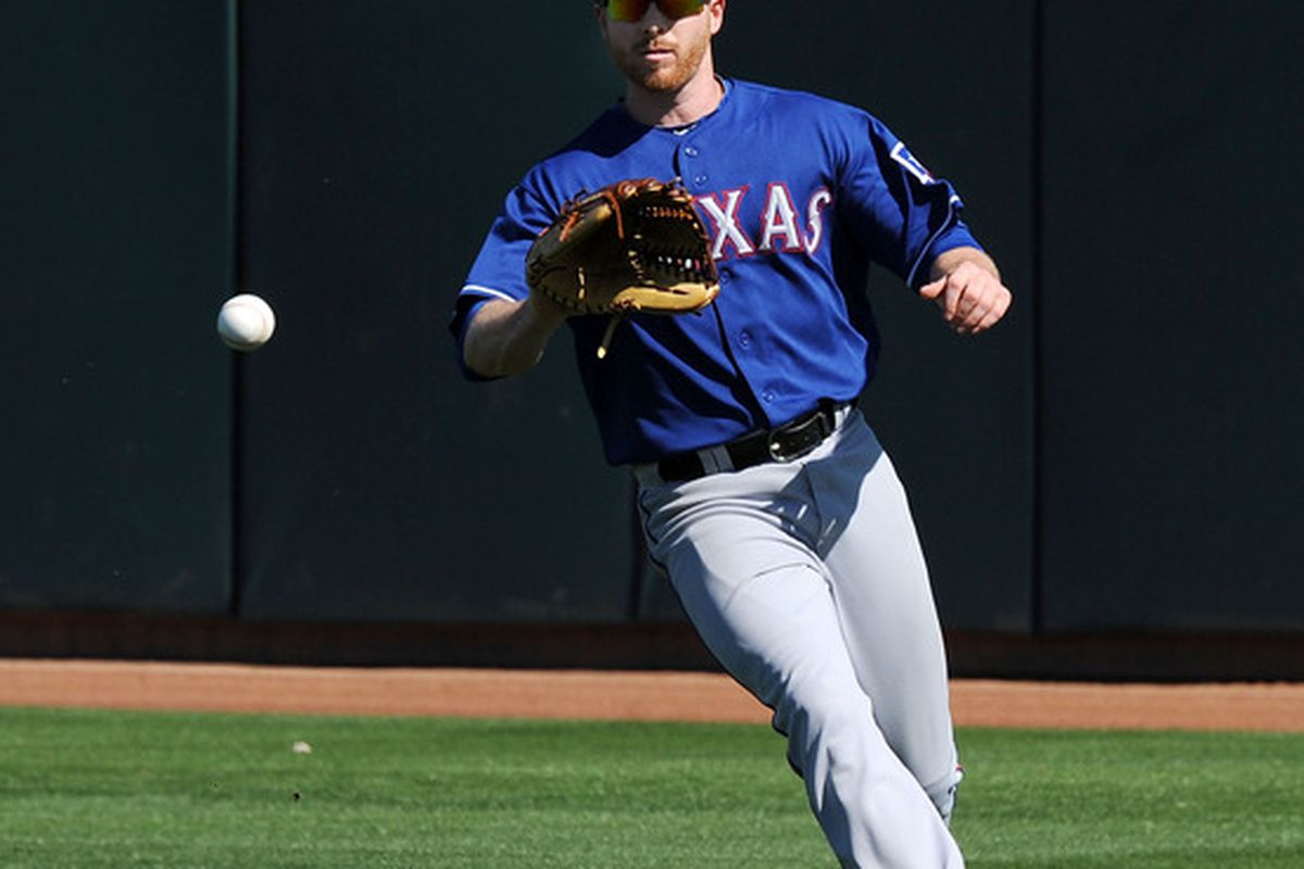 PHOENIX, AZ - MARCH 04:  Doug Deeds #65 of the Texas Rangers fields a base hit against the Oakland Athletics at Phoenix Municipal Stadium on March 4, 2011 in Phoenix, Arizona.  (Photo by Norm Hall/Getty Images)