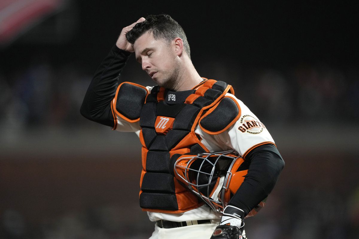 Buster Posey #28 of the San Francisco Giants reacts after a single by Gavin Lux #9 of the Los Angeles Dodgers during the ninth inning in game 5 of the National League Division Series at Oracle Park on October 14, 2021 in San Francisco, California.