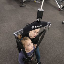 Nora Booth, 6, uses a body weight support system as she works with pediatric physical therapist Ashlyn Rittmanic at Neuroworx in Sandy on Friday, March 8, 2019. Booth, who has been diagnosed with acute flaccid myelitis, has therapy at Neuroworx several times a week. Acute flaccid myelitis affects an area of the spinal cord called gray matter, which can cause the muscles and reflexes in the body to become weak.