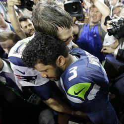 New England Patriots quarterback Tom Brady (12) hugs Seattle Seahawks quarterback Russell Wilson (3) after the NFL Super Bowl XLIX football game Sunday, Feb. 1, 2015, in Glendale, Ariz.  The Patriots won 28-24.