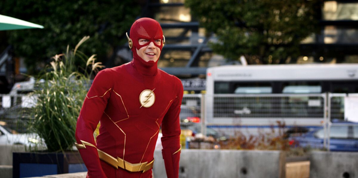 Grant Gustin, The CW's The Flash'ta bir depar atmak üzereyken kostümlü Flash olarak gülümsüyor