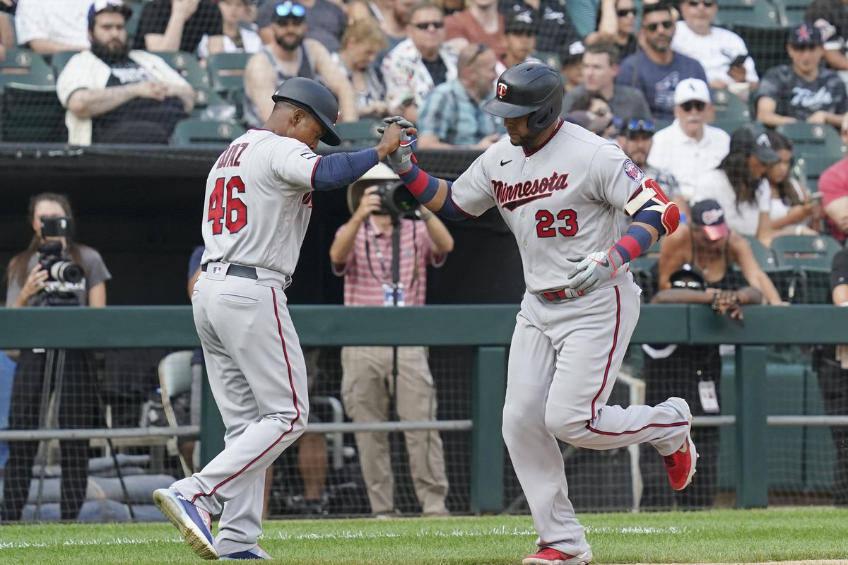 Nelson Cruz #23 of the Minnesota Twins is congratulated by third base coach Tony Diaz #46 of the Minnesota Twins following his home run against the Chicago White Sox at Guaranteed Rate Field on July 19, 2021 in Chicago, Illinois.
