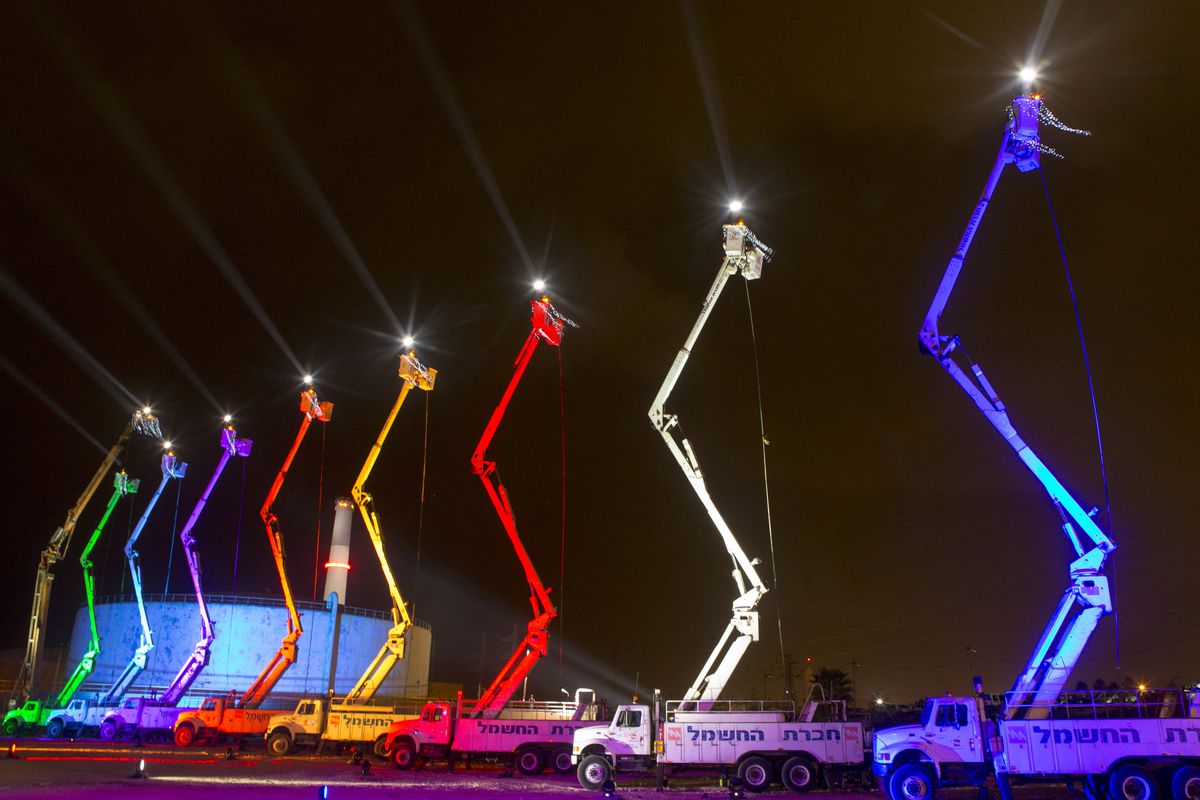 An Israeli electric  company arranges cranes in the shape of a Hanukkah menorah.