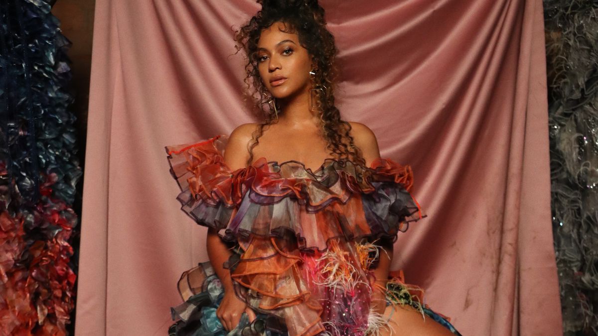 Beyonce in a multicolored dress against a pink sheet in Black Is King