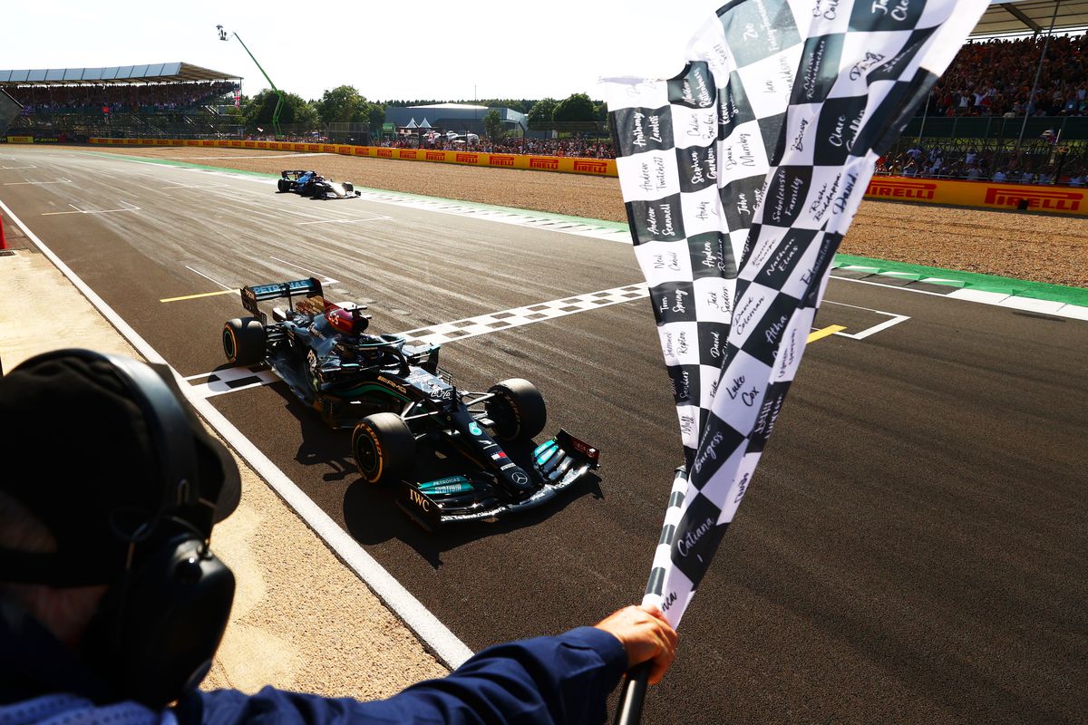 Race winner Lewis Hamilton of Great Britain driving the (44) Mercedes AMG Petronas F1 Team Mercedes W12 takes the chequered flag during the F1 Grand Prix of Great Britain at Silverstone on July 18, 2021 in Northampton, England.