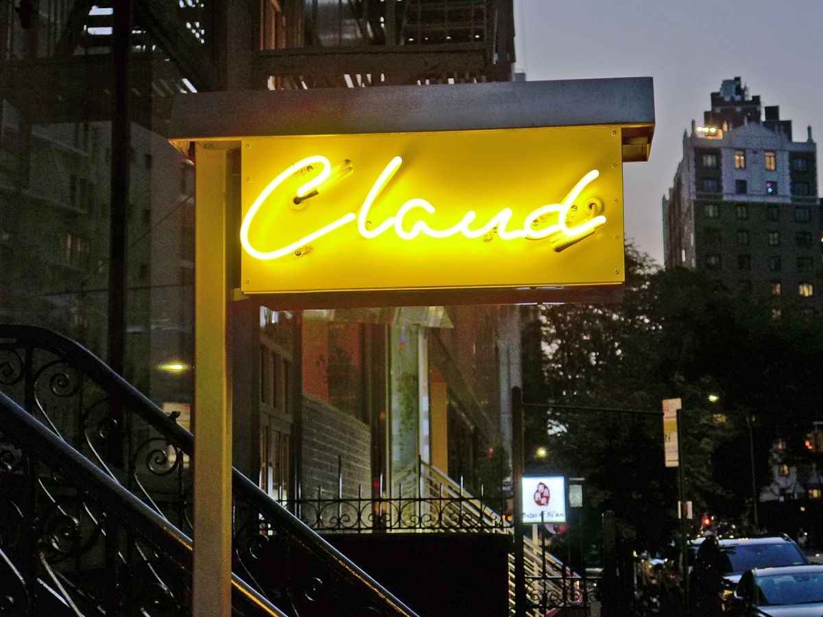 A yellow neon sign show the name of the restaurant in italic.