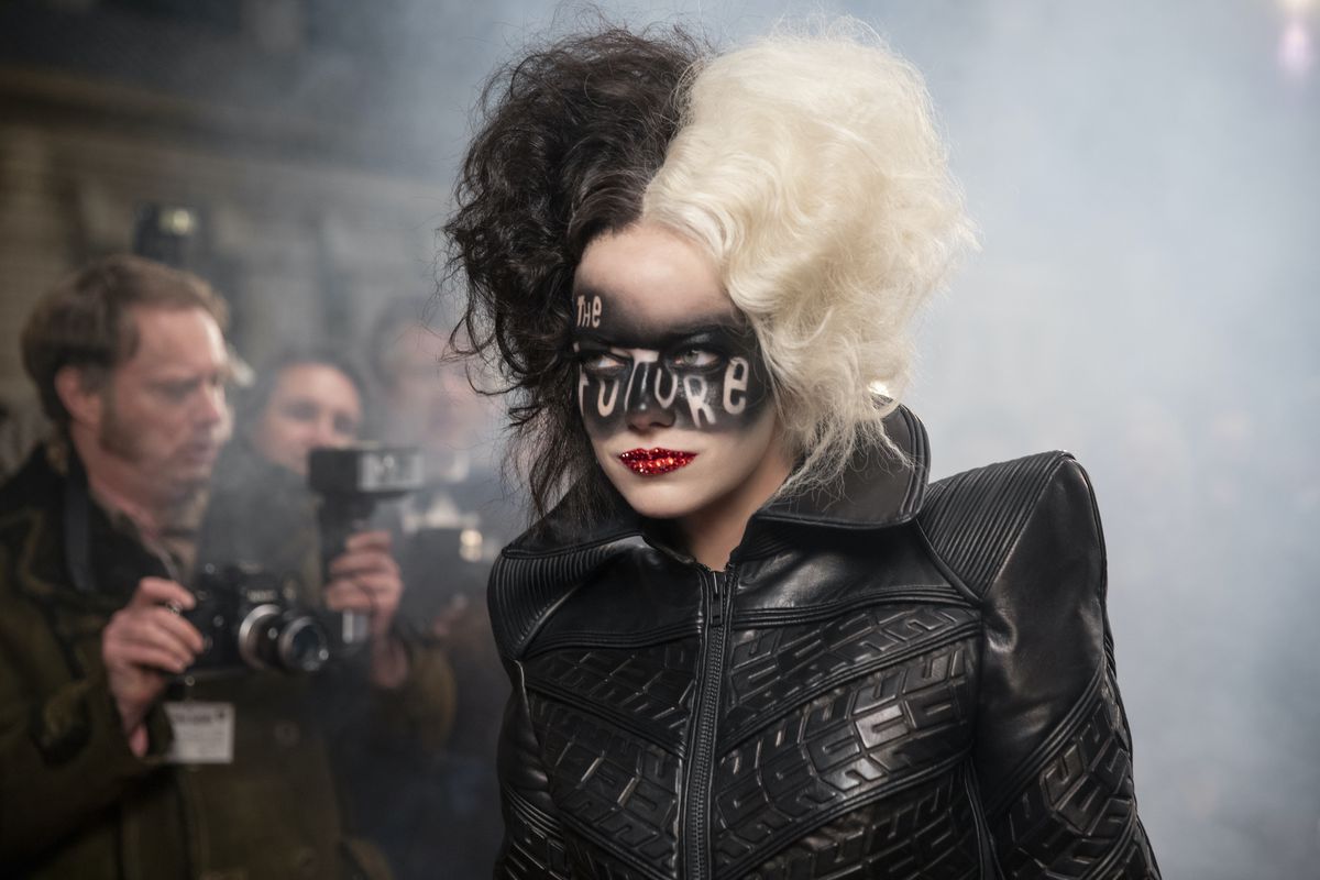 Cruella shows up at a fashion show with the words “the future” painted on her face.