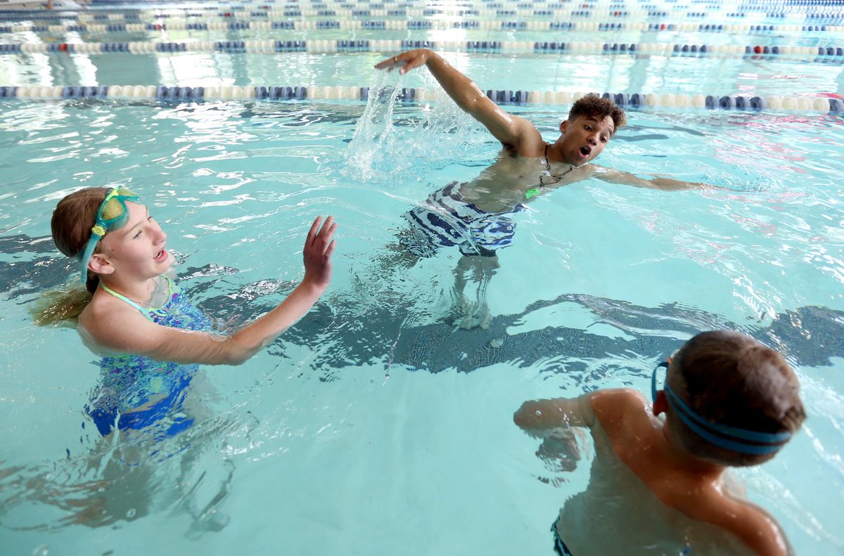 Mason Sine, center, teaches Zlata Balantceva, left, and Gene Balantceva how to swim at Fairmont Aquatic Center in Salt Lake City on Tuesday, May 22, 2018.