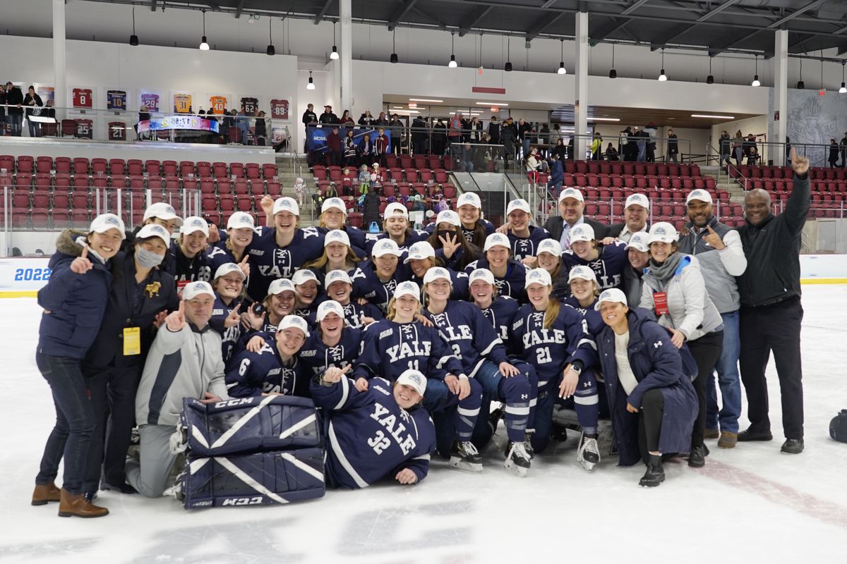 Yale’s women’s hockey players and staff gather for a celebratory photo after winning their NCAA quarterfinal game against Colgate.