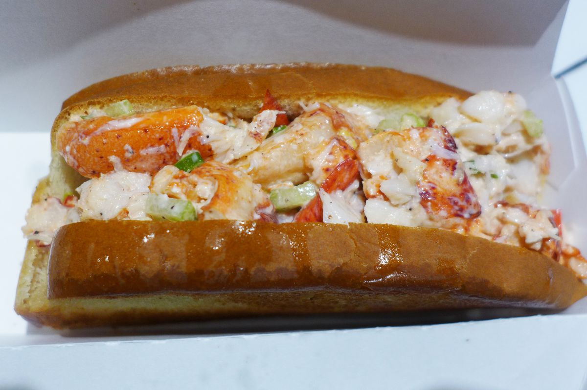 Glistening lobster meat in a roll with a bun like white bread, but toasted.