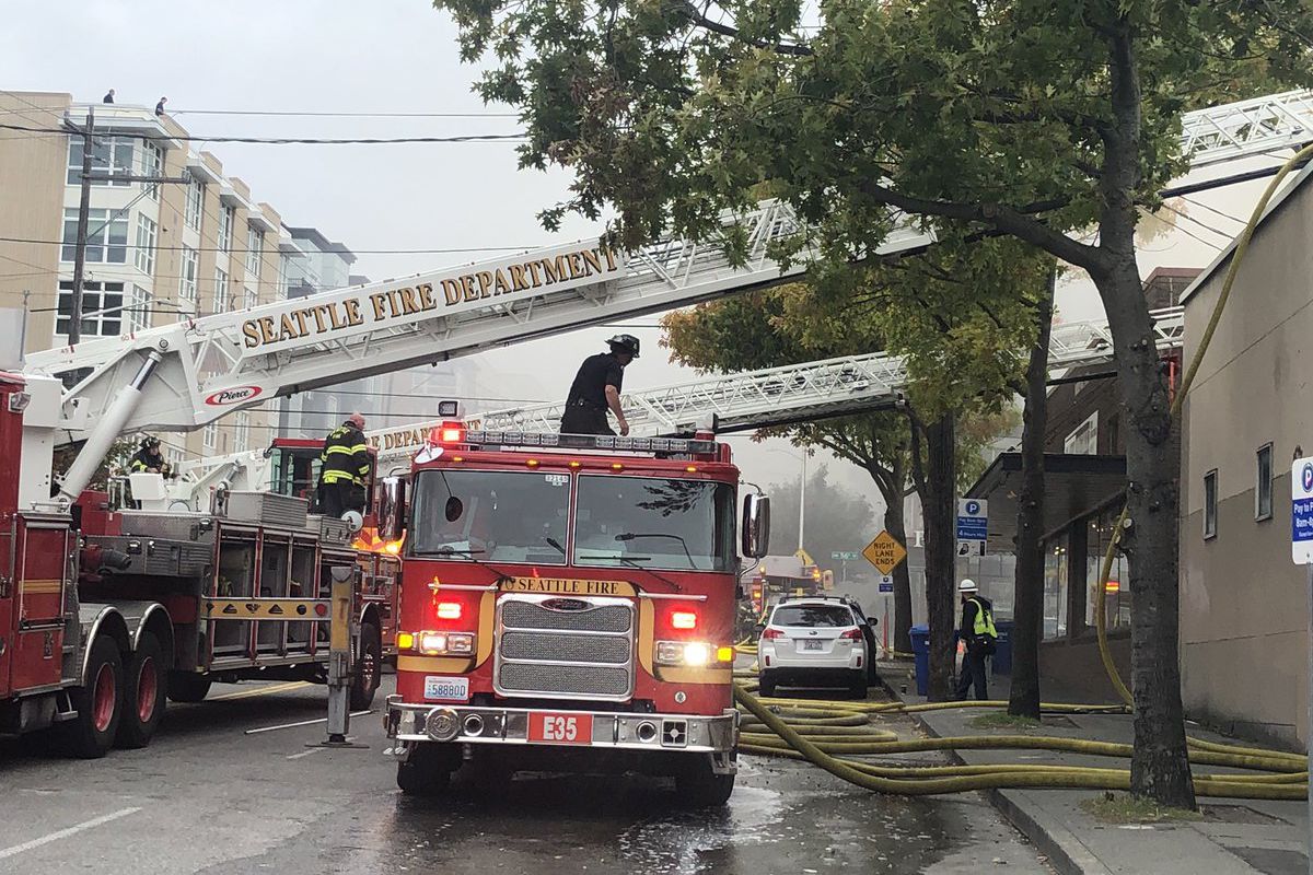 A view of a Seattle fire truck responding to a blaze on Market Street in Ballard with ladder raised.