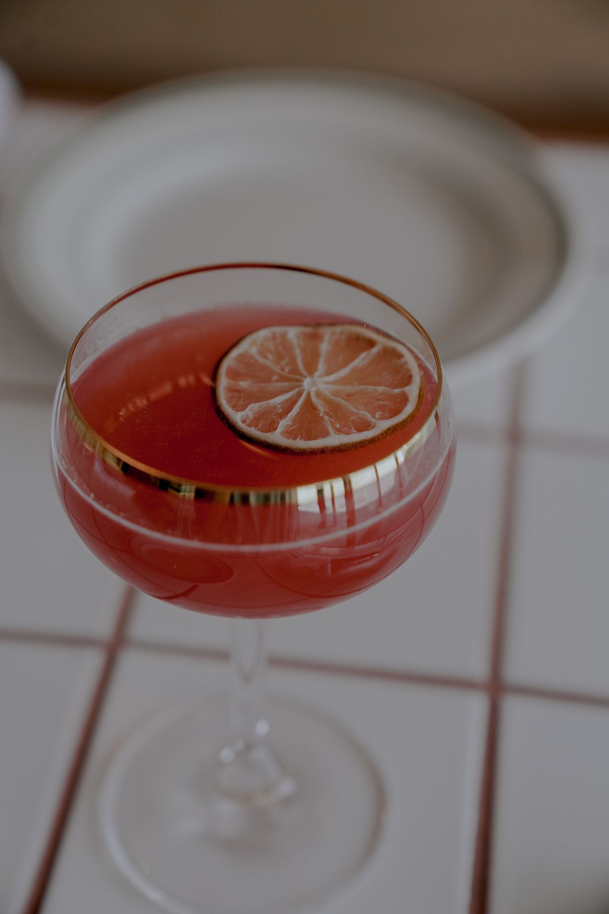 A cocktail with rum, juice, spices, and a lime slice.